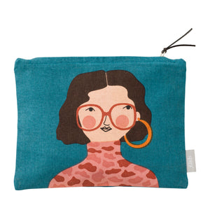 Teal zipped toiletry bag with women's face with brown hair, orange glasses and pink leopard print turtleneck.