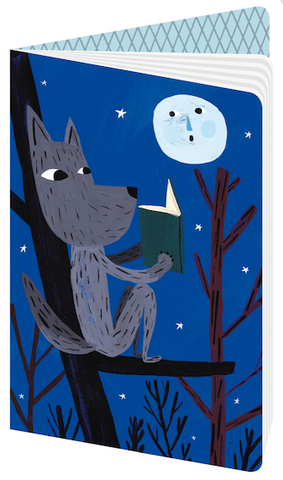 Illustration of a grey wolf perched on a tree branch reading a book while the moon watches. All on a night blue background with white stars.
