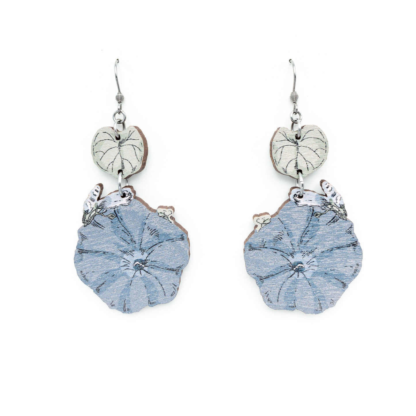Photo of a pair of wooden earrings on a white background. The earrings have a small white leaf from which a larger light blue flower hangs from. 